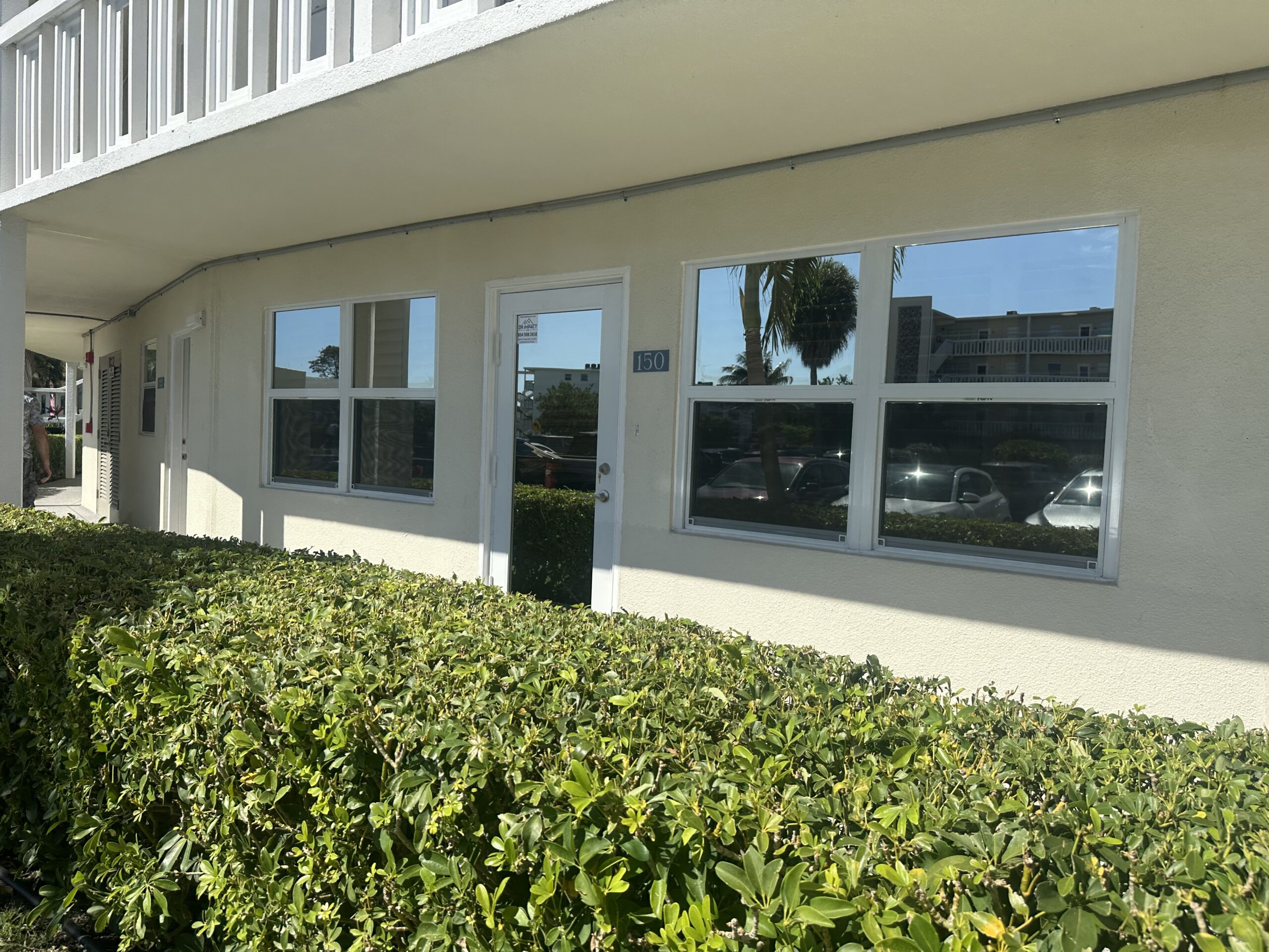 White impact windows and glass entry door at a condominium